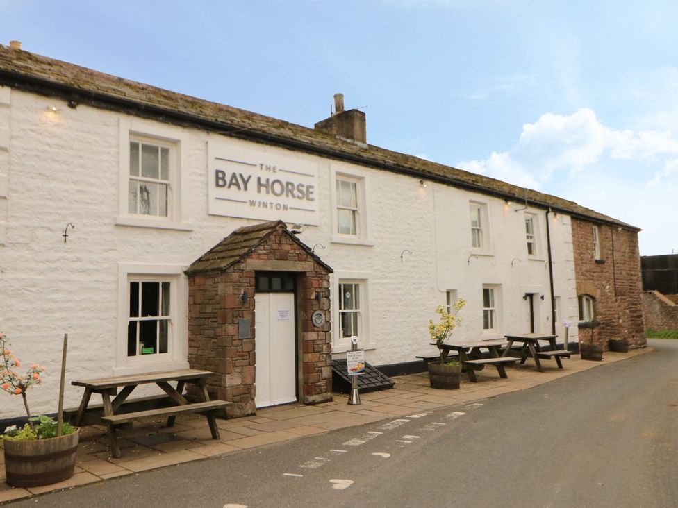 A building with tables and chairs outside at The Bay Horse in Winton