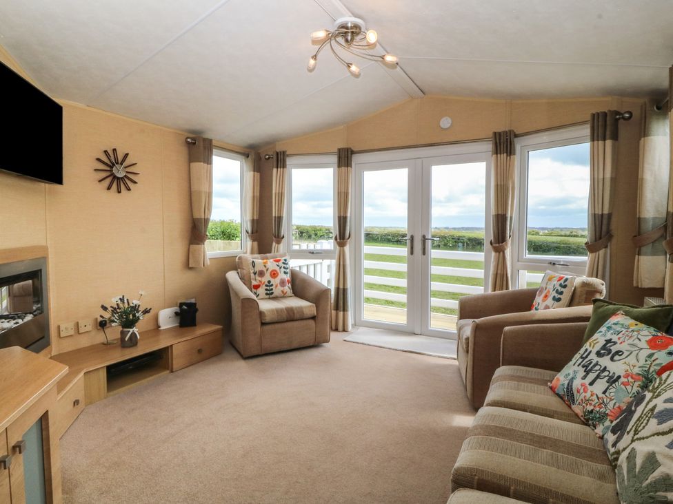 A living room with a television and seating area at Temperance Caravan in Trefor near Bodedern