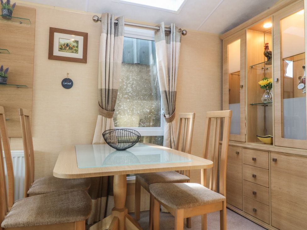 A dining room with a table and chairs at Temperance Caravan in Trefor near Bodedern
