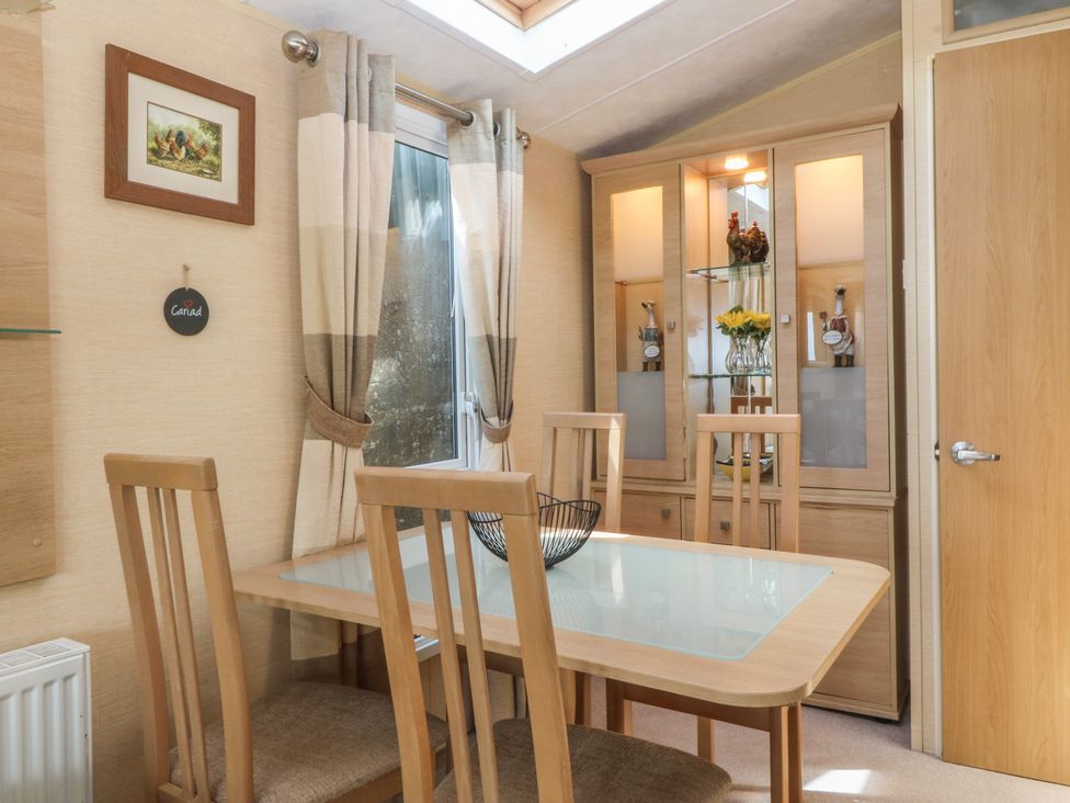 A dining room with a table and chairs at Temperance Caravan in Trefor near Bodedern
