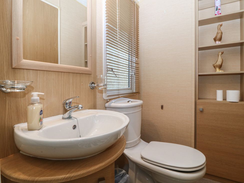 A bathroom with a sink and toilet at Temperance Caravan Trefor near Bodedern