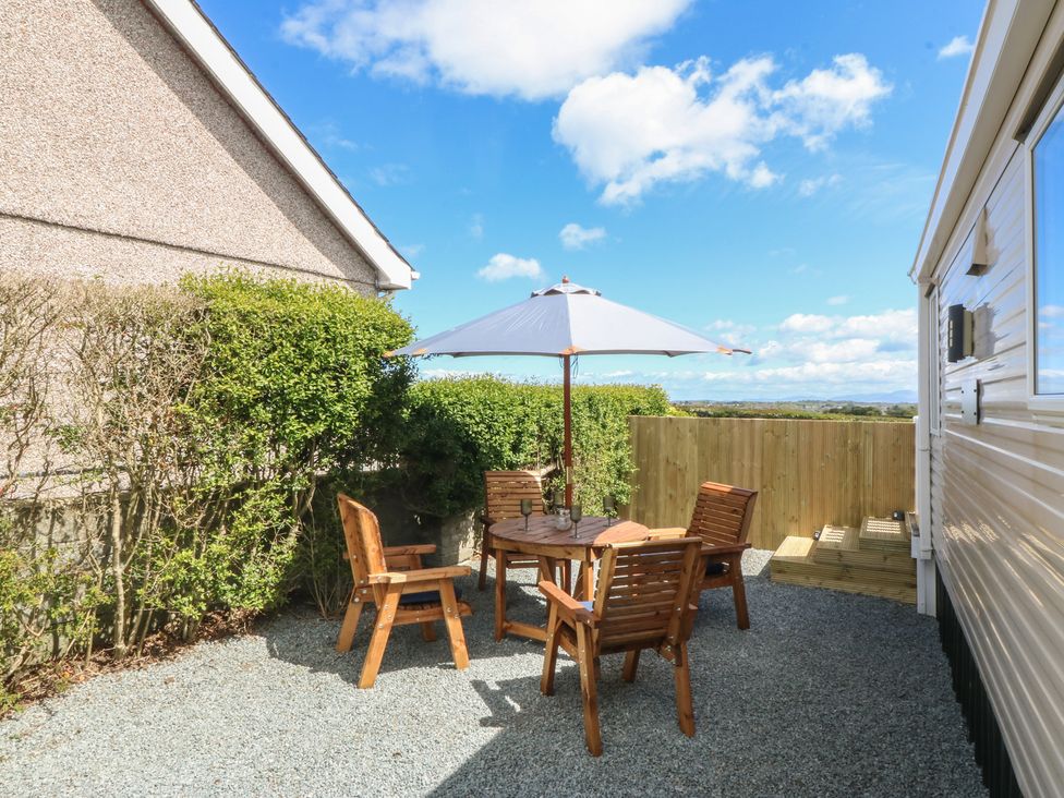 An outdoor seating area with a table and chairs at Temperance Caravan in Trefor