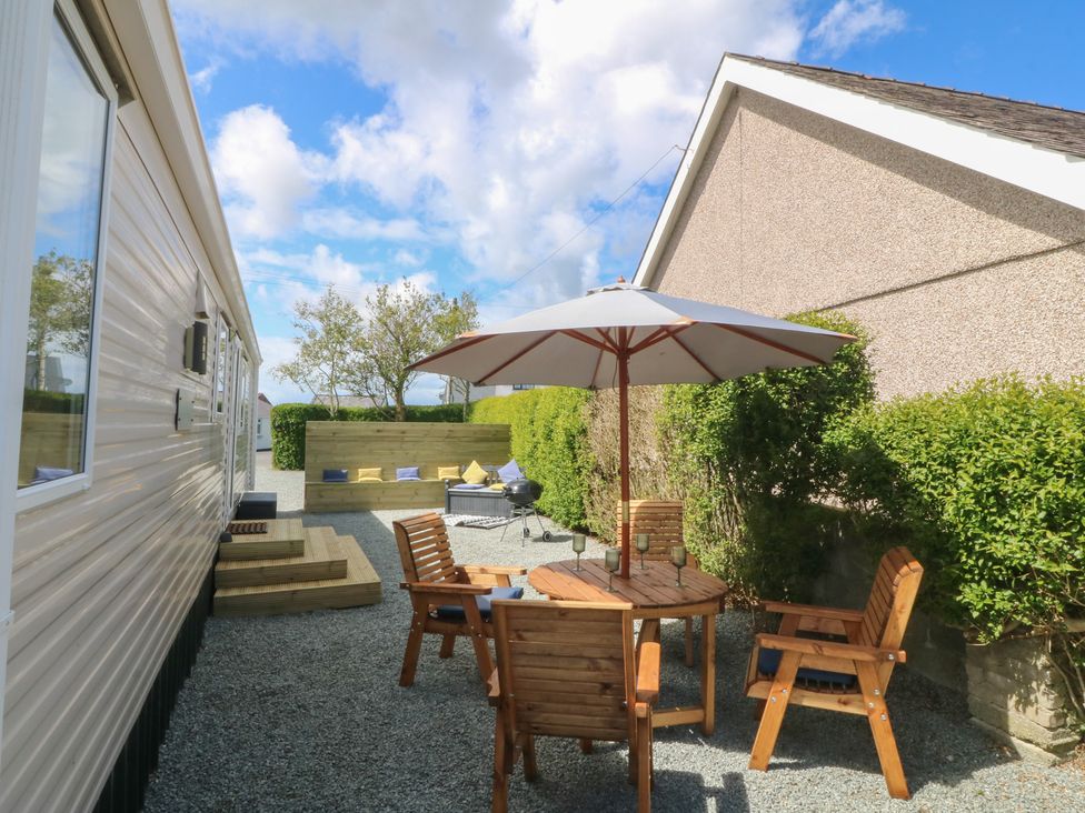 An outdoor seating area with a table and chairs at Temperance Caravan in Trefor