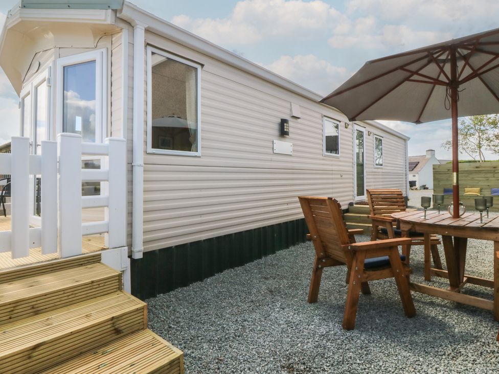 An outdoor seating area with a table and chairs at Temperance Caravan in Trefor