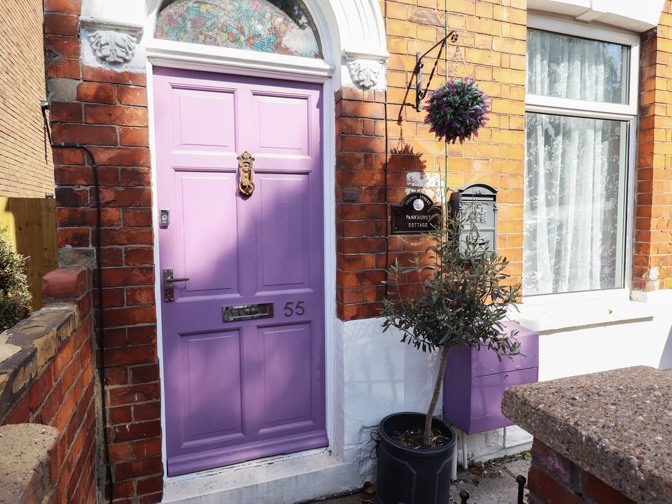 A purple door with house number and nameplate at Pankhurst Cottage in Louth