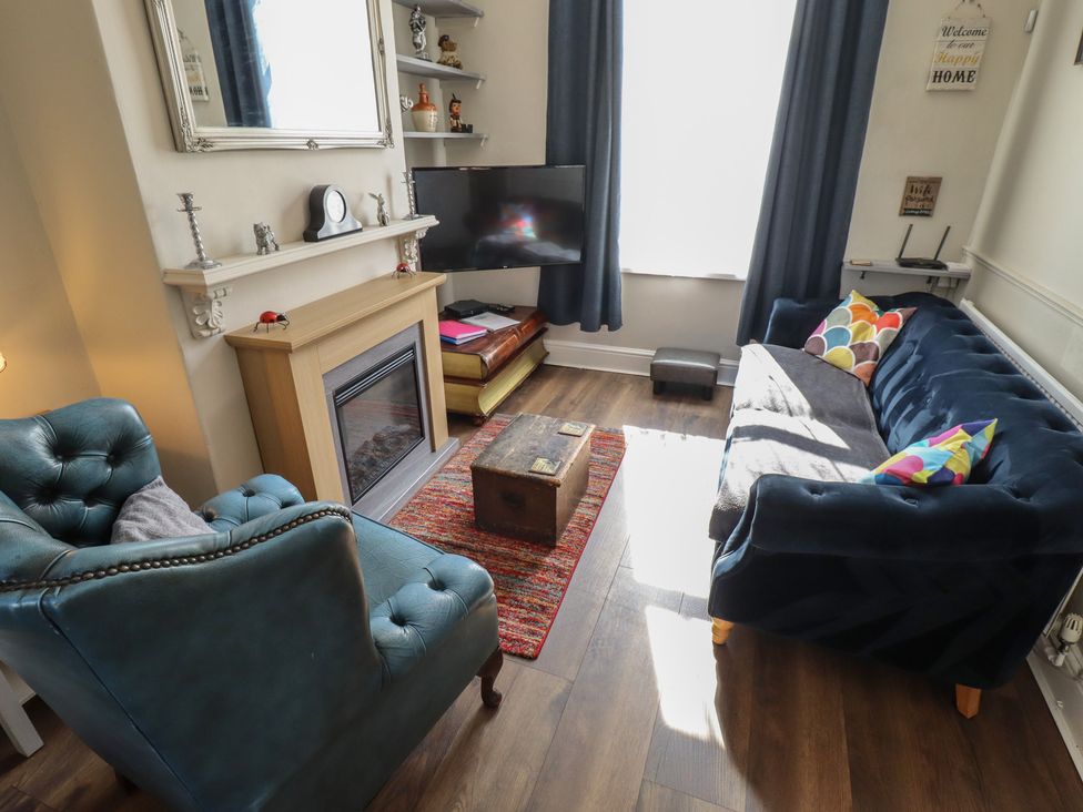 A living room with a sofa and armchair at Pankhurst Cottage in Louth