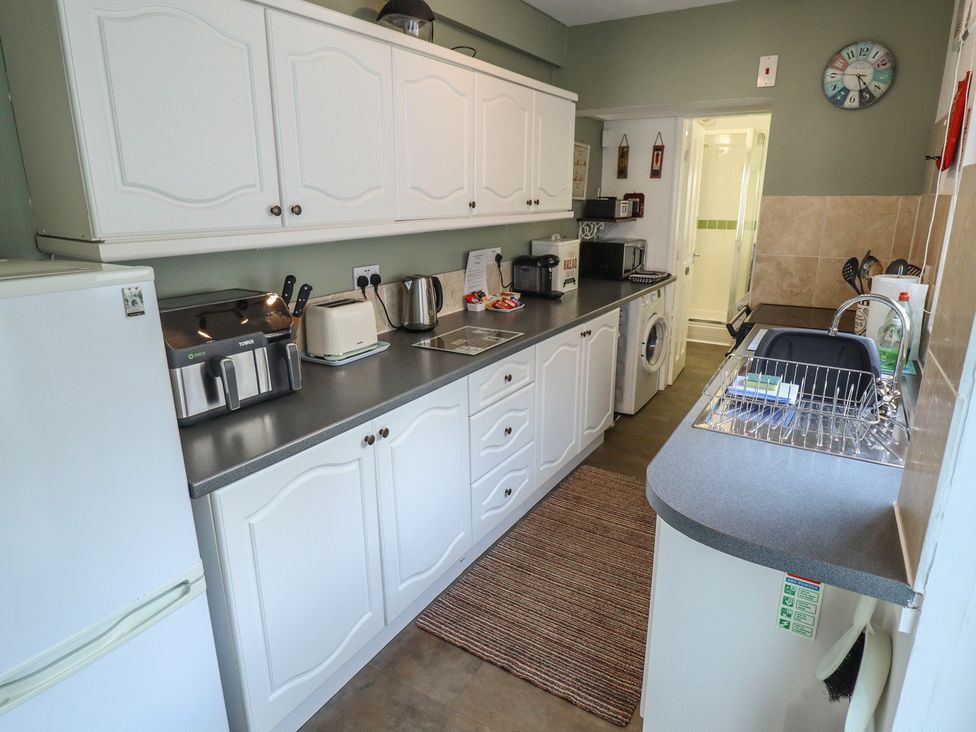 A kitchen with appliances and cabinets at Pankhurst Cottage in Louth