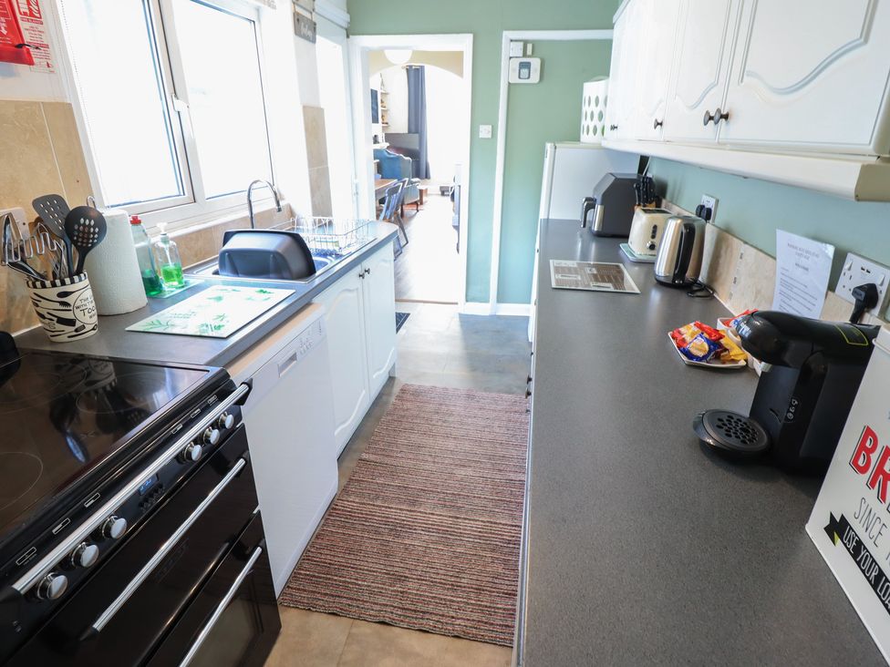 A kitchen with a stove, countertop, and appliances at Pankhurst Cottage in Louth