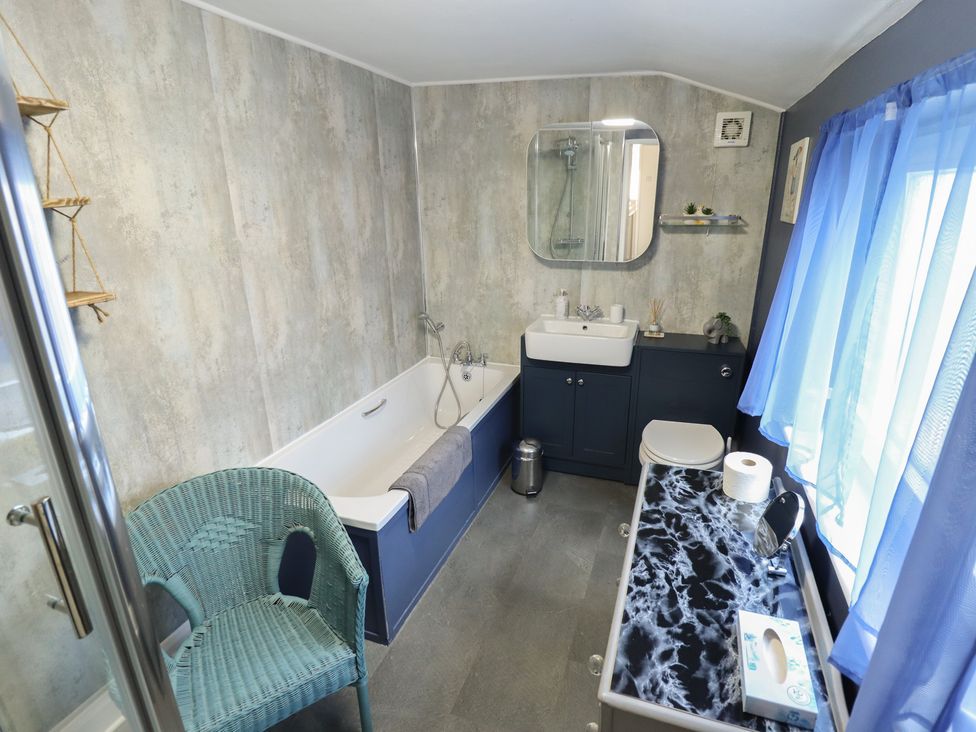 A bathroom with a bathtub, sink, and toilet at Pankhurst Cottage in Louth