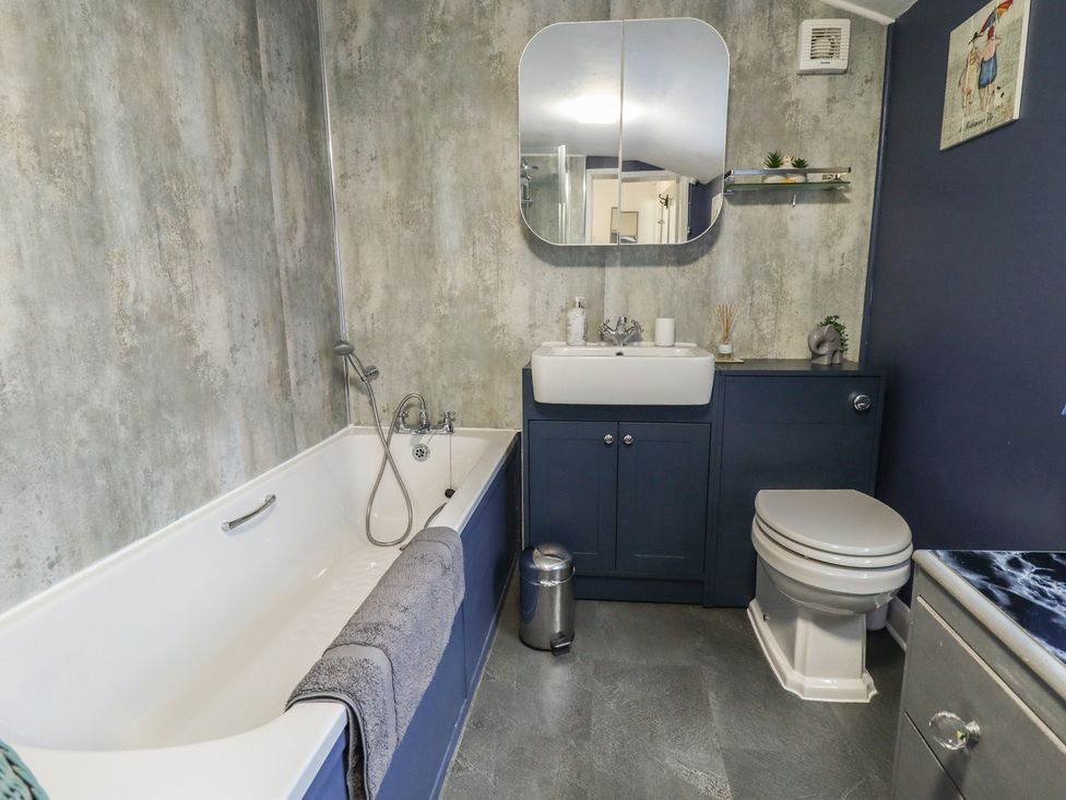 A bathroom with a bathtub, sink, and toilet at Pankhurst Cottage in Louth