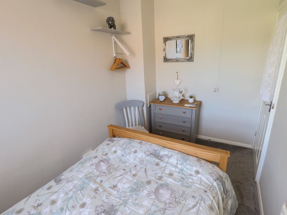 A bedroom with a bed and dresser at Pankhurst Cottage in Louth
