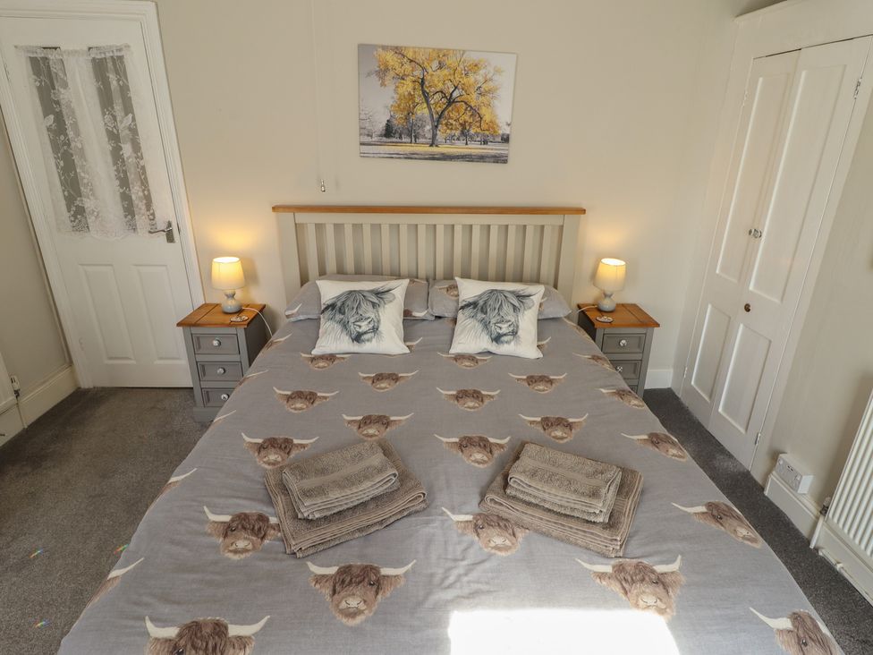A bedroom with a bed and bedside tables at Pankhurst Cottage in Louth