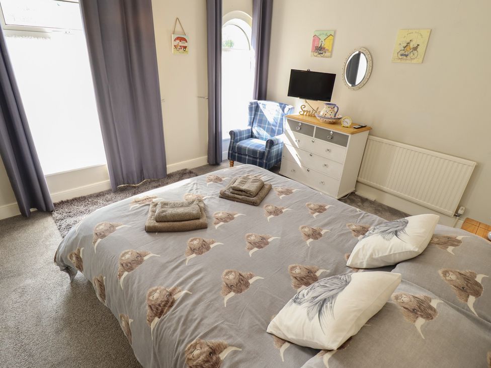 A bedroom with a bed and a television at Pankhurst Cottage in Louth
