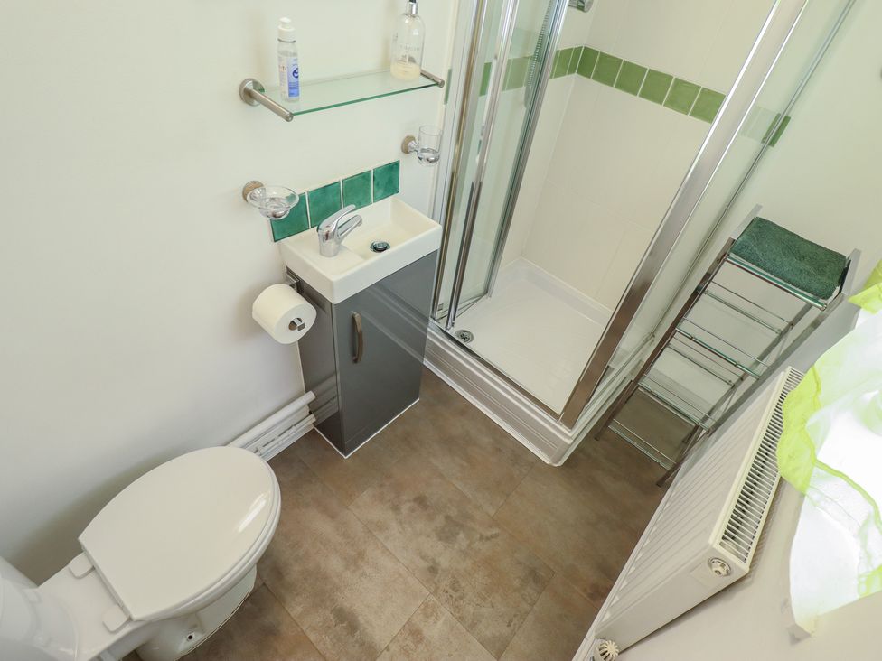 A bathroom with a sink and shower at Pankhurst Cottage in Louth
