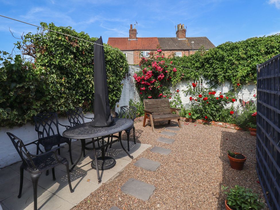 A garden with a table and chairs at Pankhurst Cottage in Louth