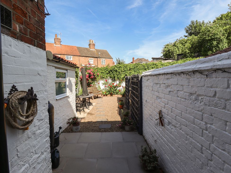 A garden with a pathway and furniture at Pankhurst Cottage in Louth
