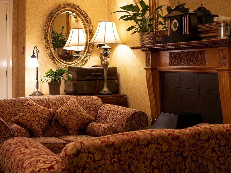 A living room with a sofa and lamp at Lonsdale House Bowness-On-Windermere