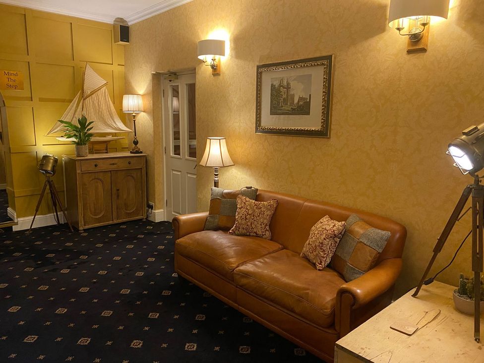 A living room with a sofa and decorative elements at Lonsdale House Bowness-On-Windermere
