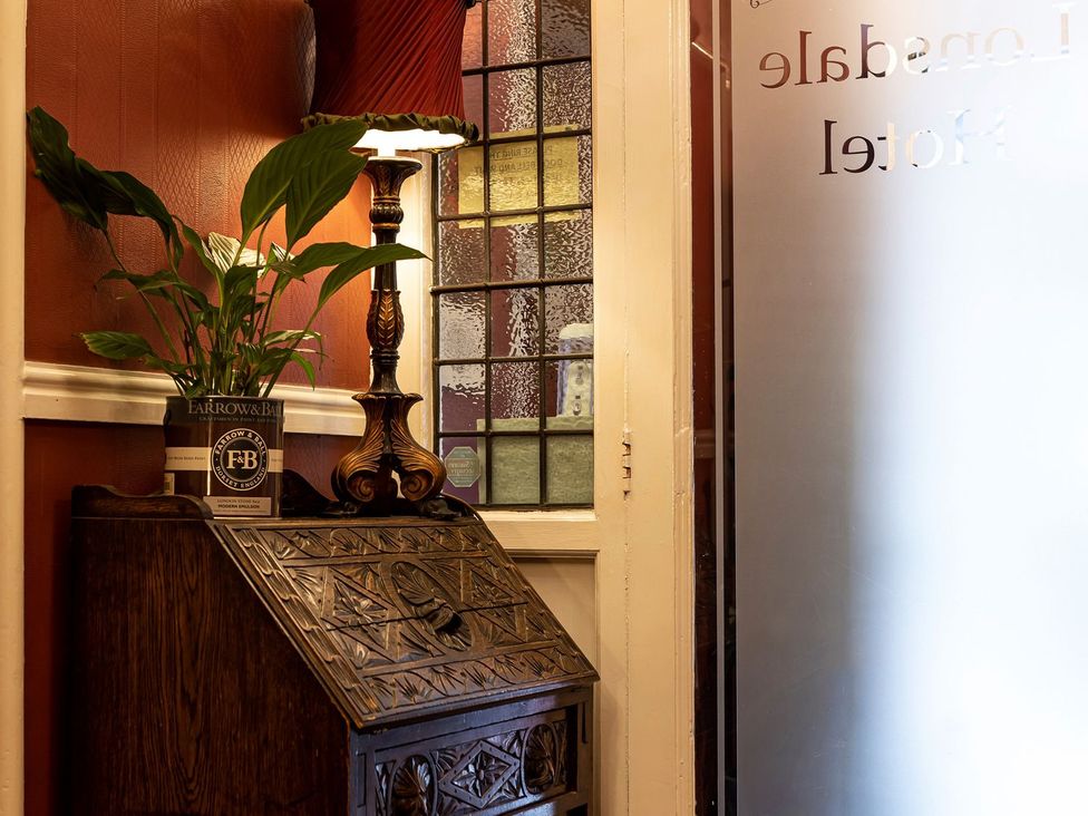 A lobby with a plant and lamp near a decorative box at Lonsdale House in Bowness-On-Windermere