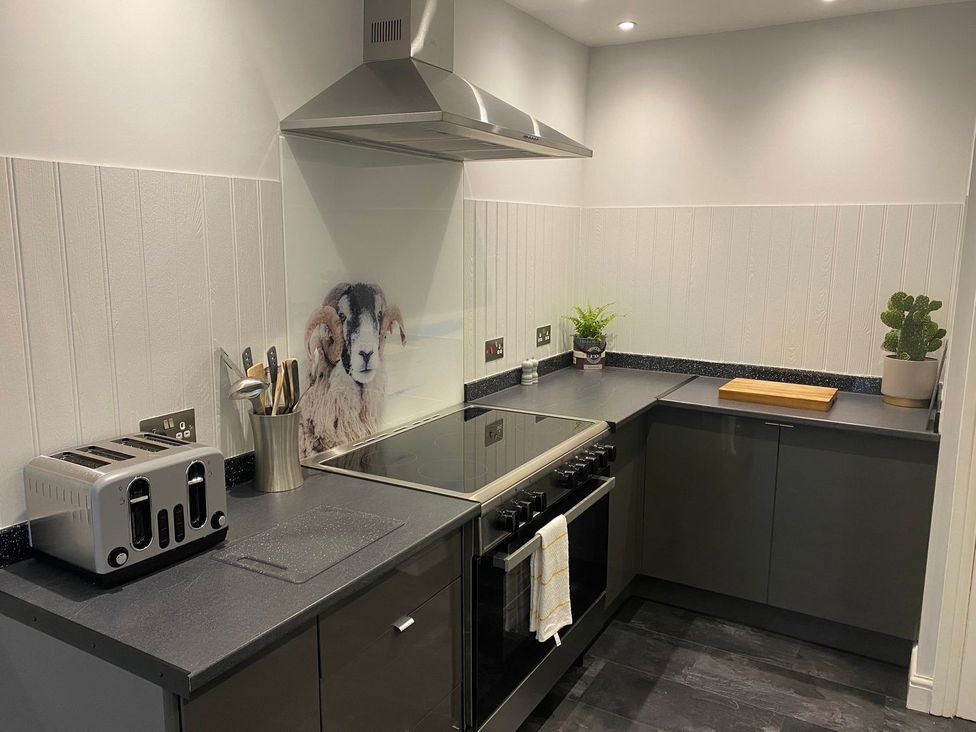A kitchen with a stove and a toaster at Lonsdale House in Bowness-On-Windermere