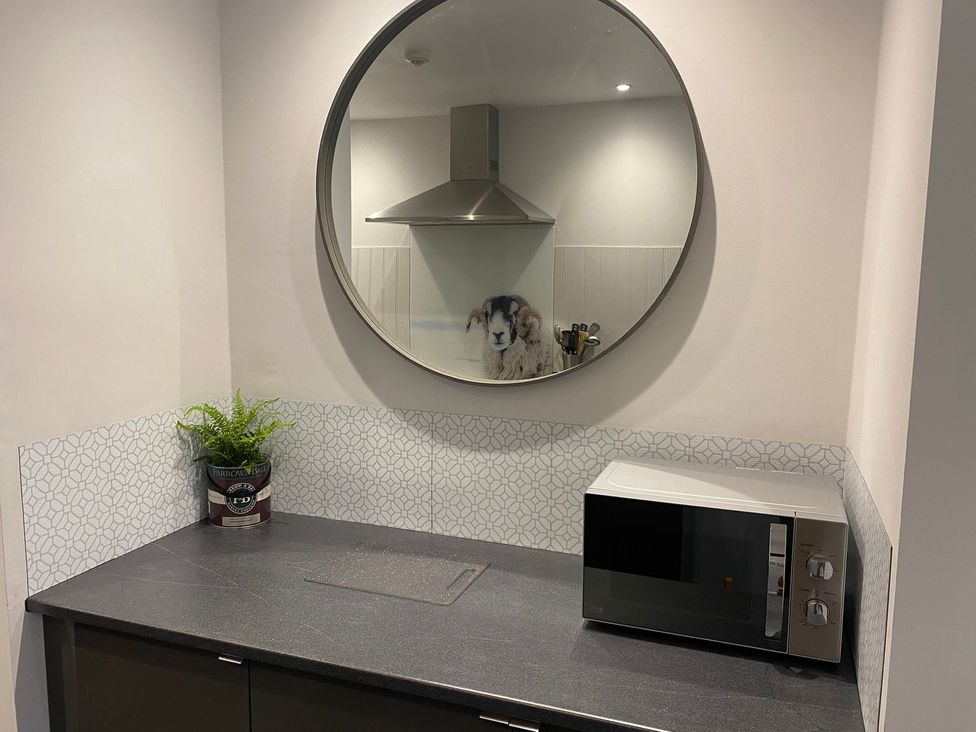 A kitchen with a microwave and a plant at Lonsdale House Bowness-On-Windermere