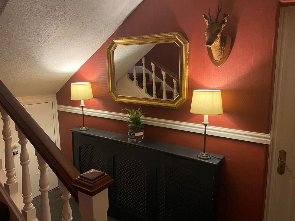 A hallway with a staircase and decorations at Lonsdale House in Bowness-On-Windermere