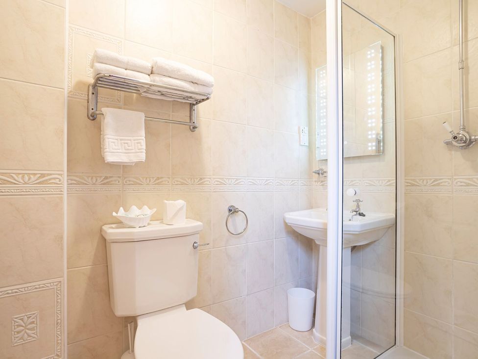 A bathroom with a shower, sink, and toilet at Lonsdale House Bowness-On-Windermere