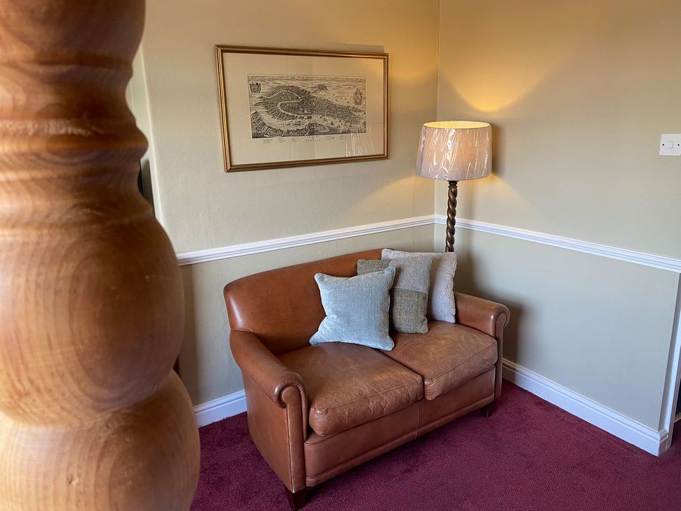 A sofa with cushions and a lamp in a snug at Lonsdale House in Bowness-On-Windermere