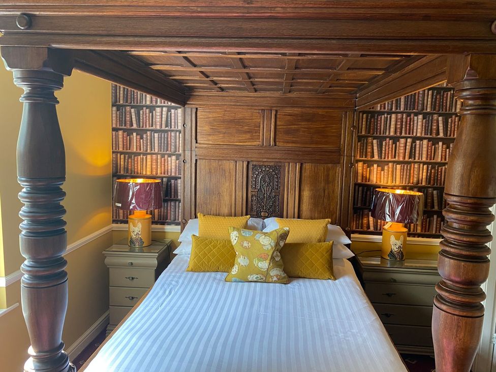 A bedroom with a four-poster bed and lamps at Lonsdale House in Bowness-On-Windermere