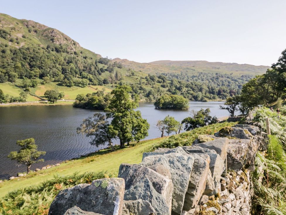 A lake surrounded by trees with a stone wall in Bowness-On-Windermere at Lonsdale House