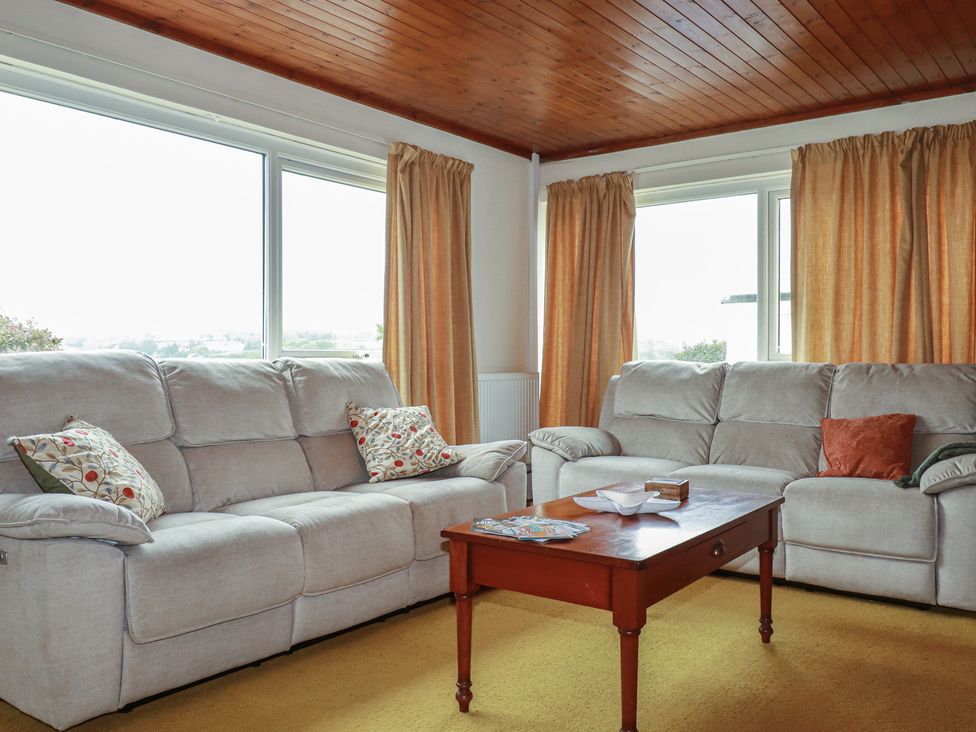 A living room with sofas and a table at 7 Chycoose Parc