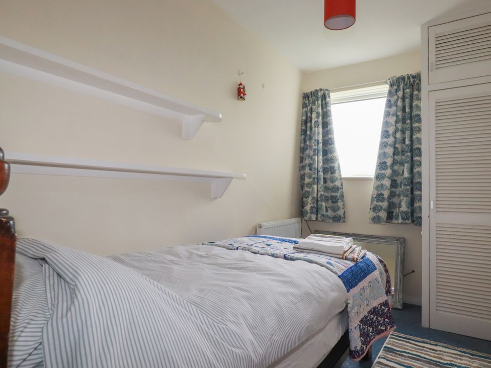 A bedroom with a bed and shelves at 7 Chycoose Parc