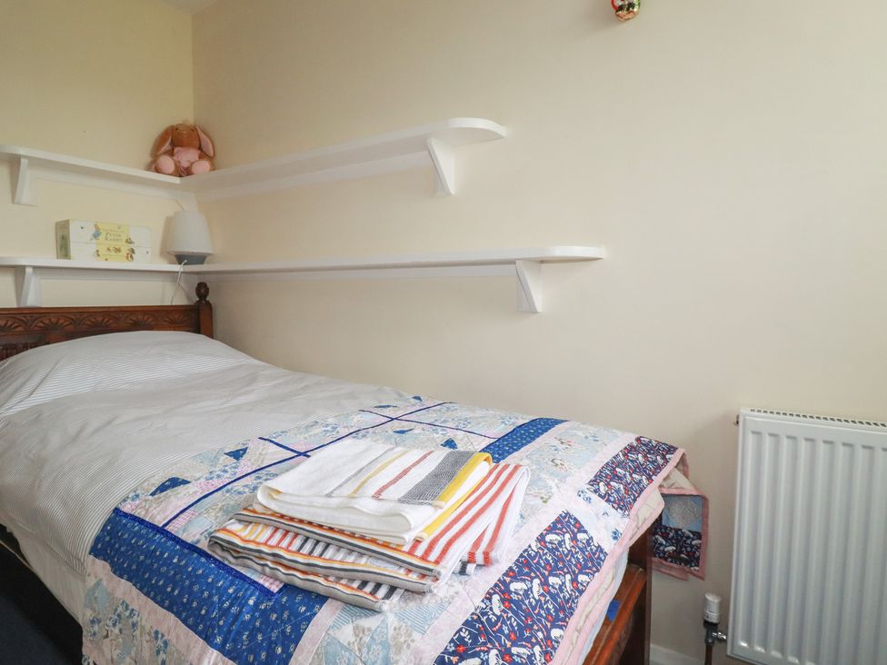 A bedroom with a bed and shelves at 7 Chycoose Parc