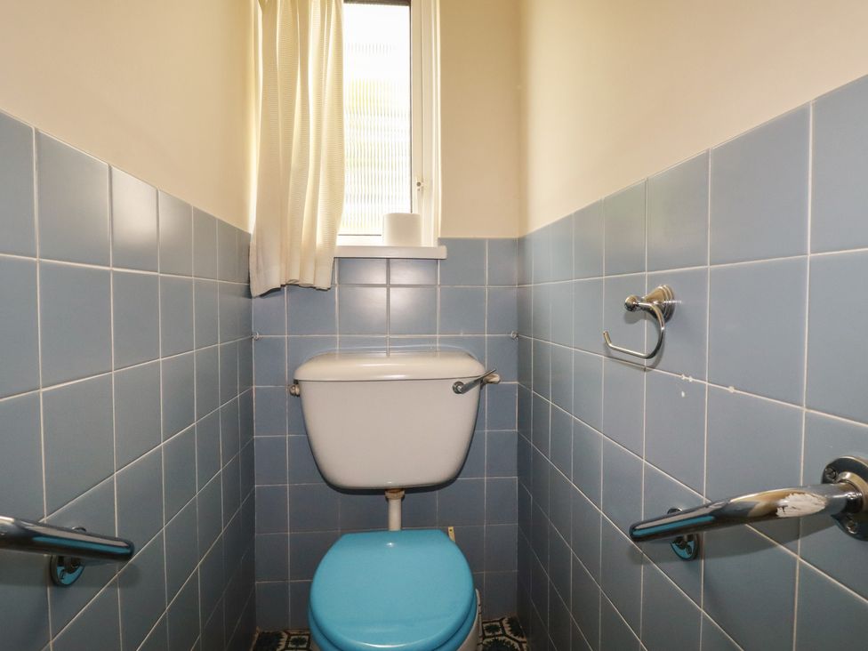 A bathroom with a toilet and window at 7 Chycoose Parc