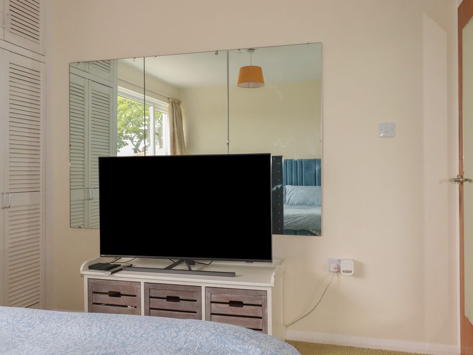 A bedroom featuring a television on a dresser and a mirror on the wall at 7 Chycoose Parc 