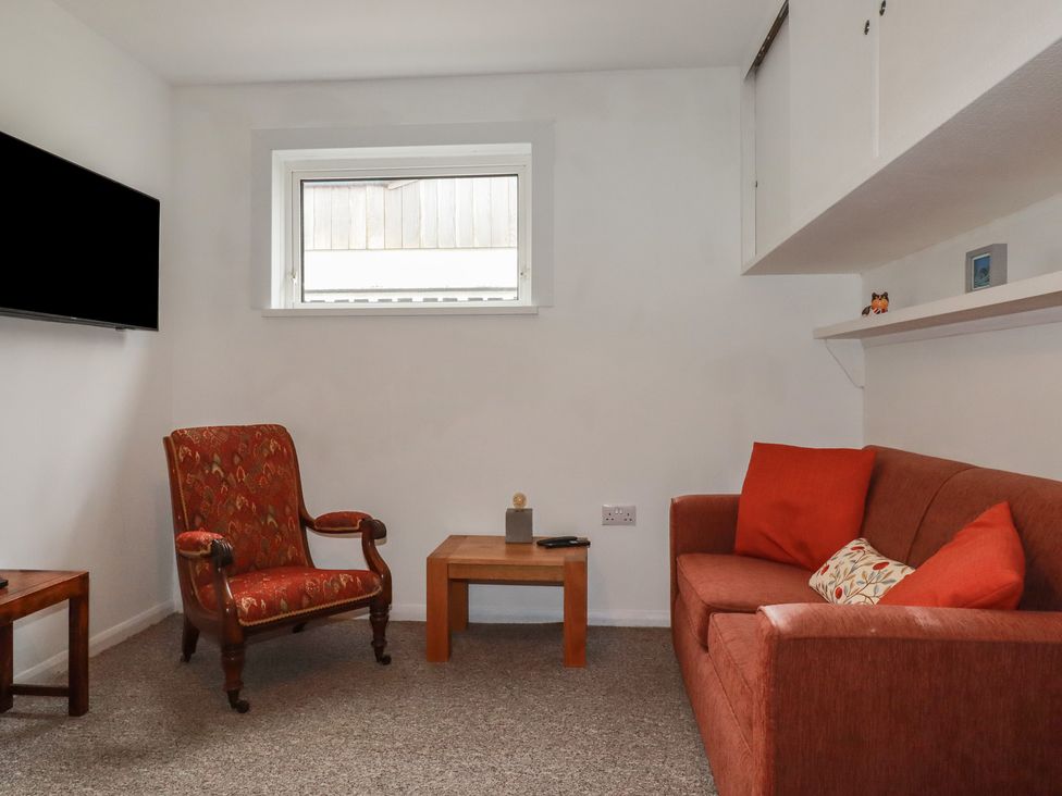 A living room with a television and seating at 7 Chycoose Parc