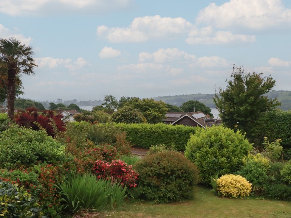 A garden view with various plants and houses at 7 Chycoose Parc