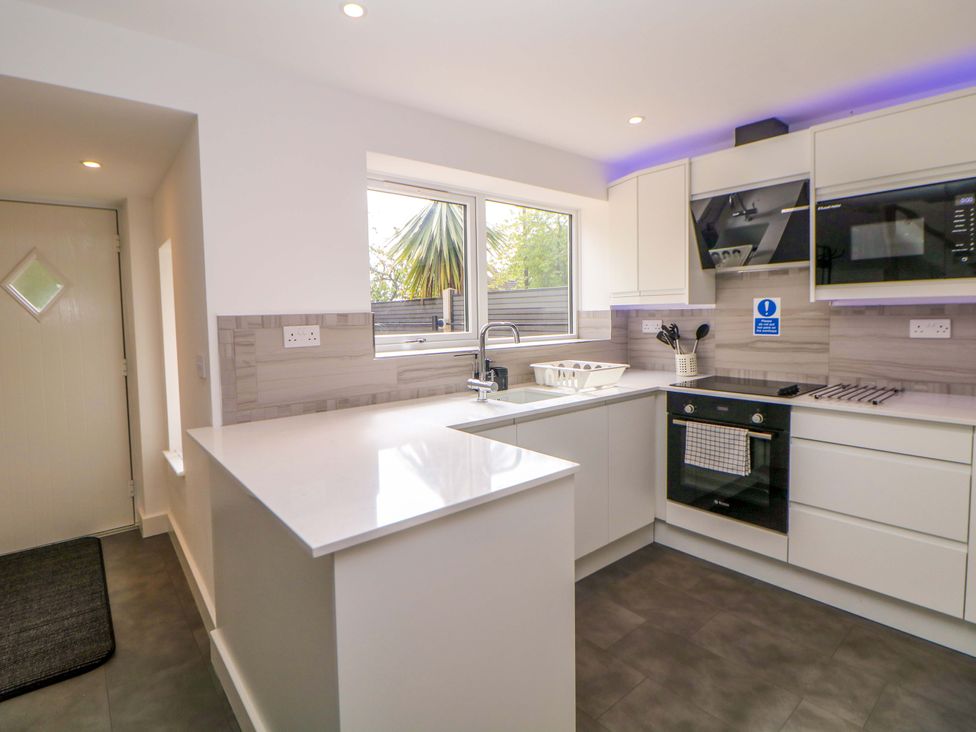 A kitchen with a sink, oven, and windows at 49 Rushley Road in Sheffield