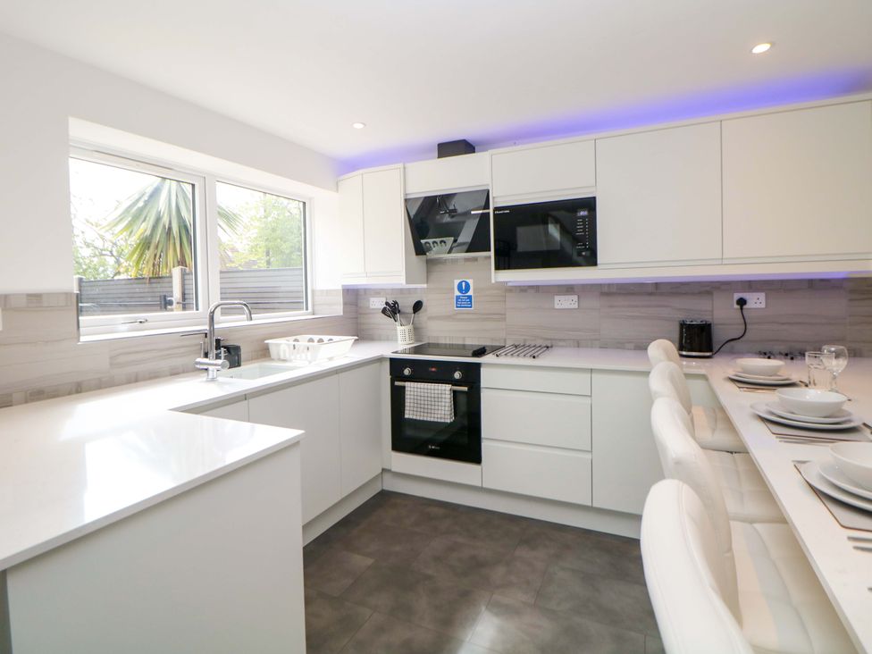 A kitchen with a sink, microwave, oven, and countertop at 49 Rushley Road, Sheffield
