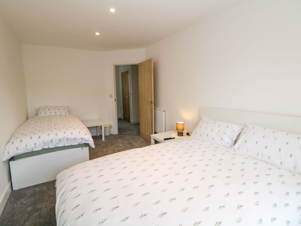 A bedroom with two beds and a side table at 49 Rushley Road in Sheffield