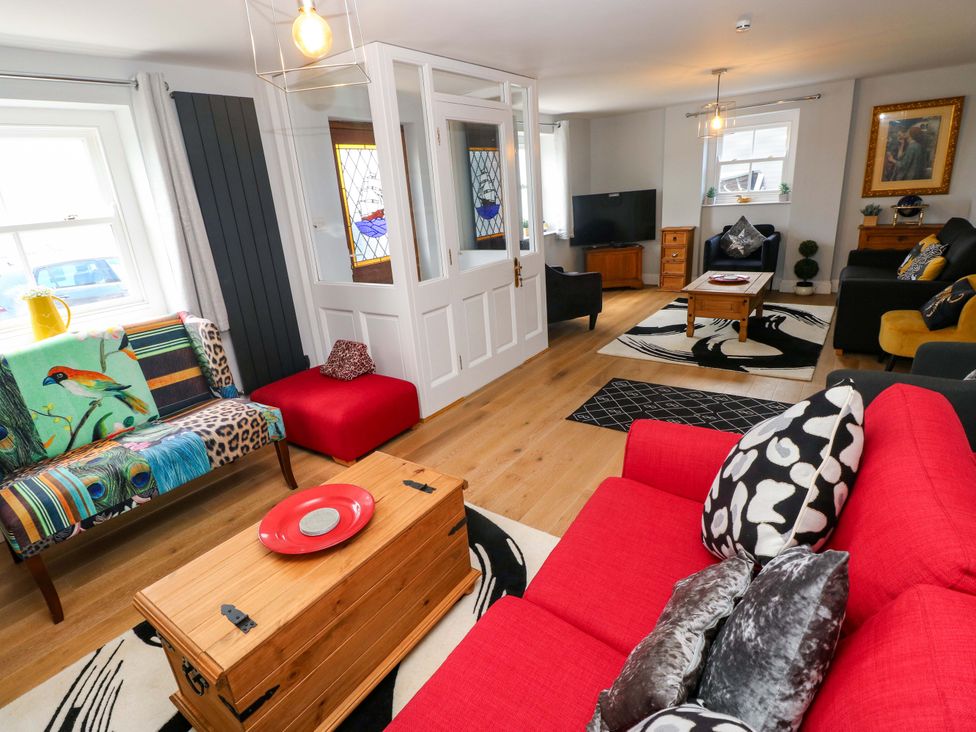 A living room with a sofa, coffee table and television at Newgale Cottage in Haverfordwest