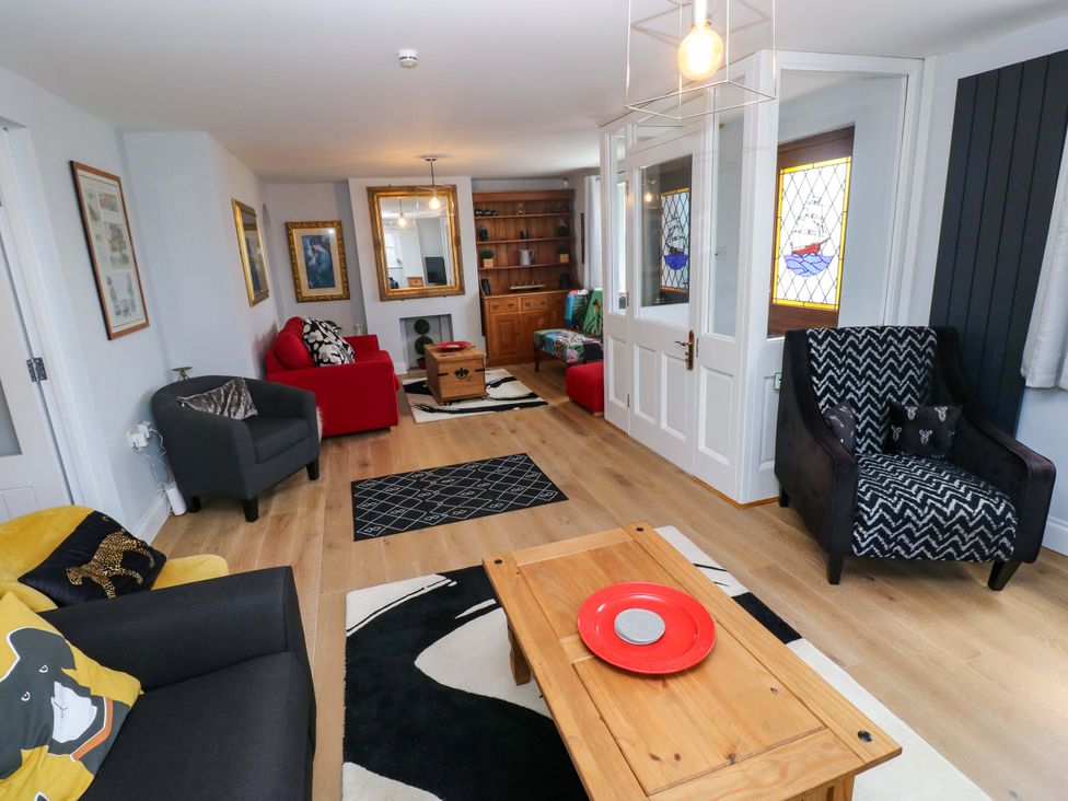 A living room with a coffee table and seating areas at Newgale Cottage in Haverfordwest