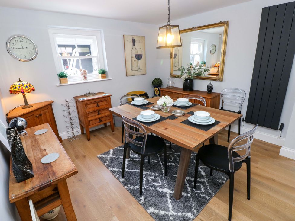 A dining room with a table set for dinner at Newgale Cottage in Haverfordwest