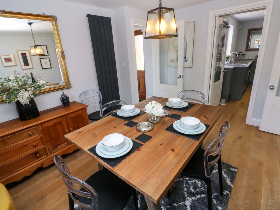 A dining room with a wooden table and chairs at Newgale Cottage in Haverfordwest