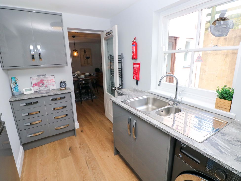 A kitchen with cabinets and a sink at Newgale Cottage in Haverfordwest