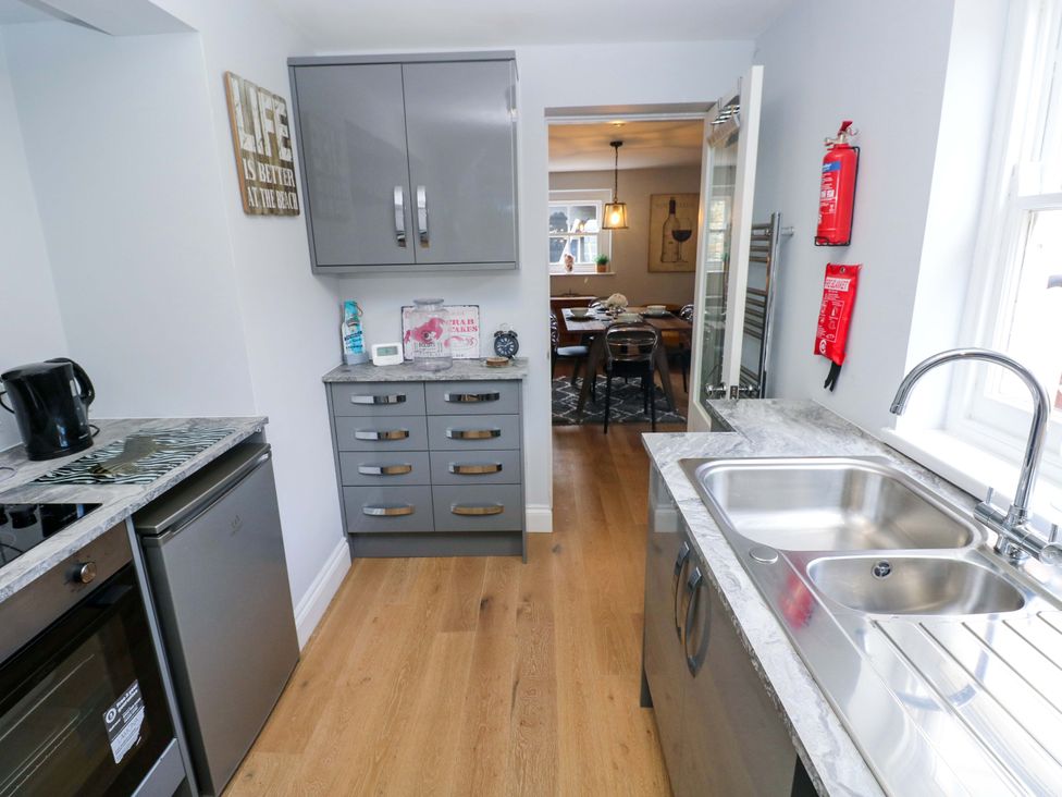 A kitchen with appliances and cabinets at Newgale Cottage Haverfordwest
