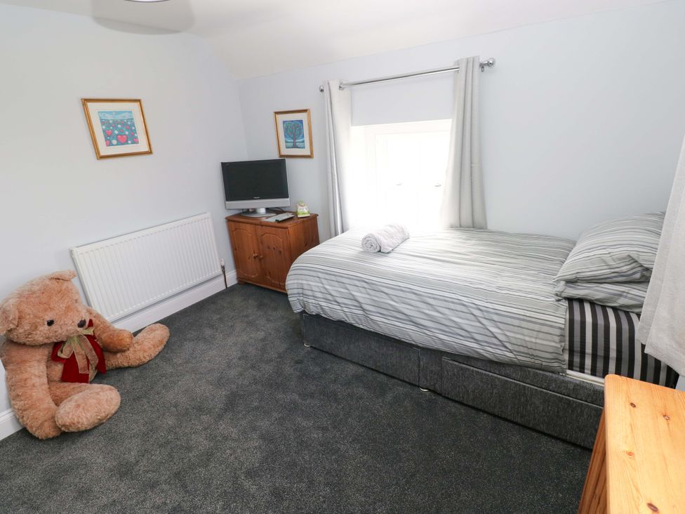 A bedroom with a bed and television at Newgale Cottage in Haverfordwest