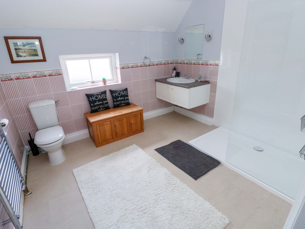 A bathroom with a shower and wash basin at Newgale Cottage in Haverfordwest