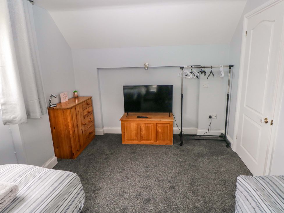 A bedroom with a television and dresser at Newgale Cottage in Newgale