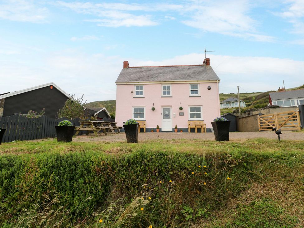 A house with a table and chairs outside at Newgale Cottage in Newgale